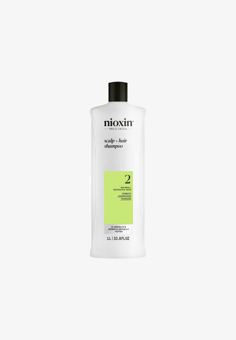Nioxin Scalp + Hair Shampoo in een heldere, hoge plastic fles met een zwarte dop; voorzien van een groene label die fase 2 voor natuurlijk haar aanduidt.