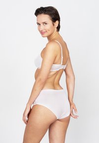 Ensemble de lingerie rose clair, comprenant un soutien-gorge lisse avec des bordures en dentelle et un culotte taille haute sans coutures assortie, mettant en valeur un tissu doux et extensible.