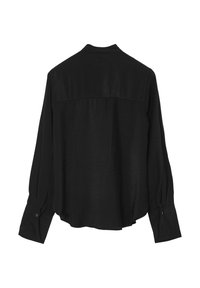 Chemise noire à manches longues avec une coupe décontractée, un léger éclat, un ourlet arrondi et des poignets boutonnés. Détails de couture au niveau du dos.