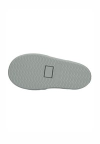 Suela de zapato de goma gris con un patrón de zigzag texturizado, que presenta un área de marca rectangular y una hendidura redonda cerca del centro.