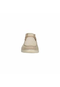 Chaussure en suède beige à bride cheville avec un bout rond, dotée de lacets fins, d'un design minimaliste et d'une surface texturée sur une semelle blanche flexible.