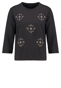 Sudadera negra de manga larga con bordados decorativos de cuentas en patrones geométricos en la parte frontal, cuello redondo y mangas con puños.