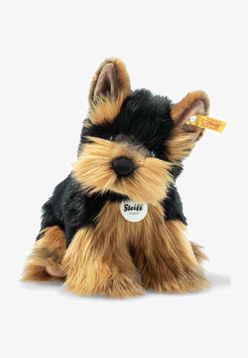 Stuffed toy resembling a Yorkshire Terrier, featuring a black and tan plush fur, pointed ears, round eyes, and a Steiff tag on the collar.