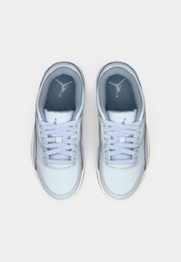 Gaiši zili un pelēki Air Jordan sporta apavi ar šņorēm, skatīti no augšas uz balta fona.