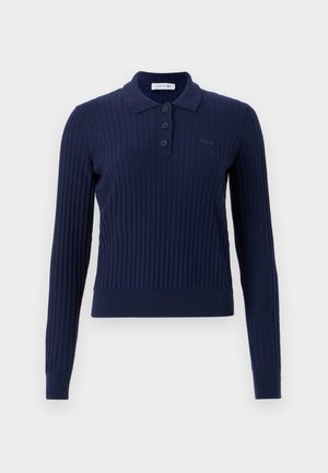 Navy ribbed long-sleeve polo shirt with a collar, four-button placket, and subtle logo detail embroidered on the chest.