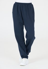 Mörkblå sweatpants gjorda av mjukt, andningsbart tyg. Har ett elastiskt midjeband, sidofickor och en avslappnad passform.