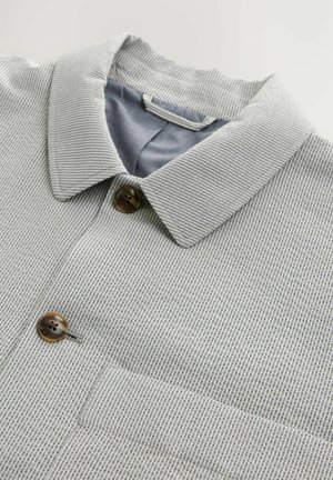 Gray patterned shirt featuring a collared neckline, two brown buttons, and a blue inner lining. Textured fabric with horizontal stripes.