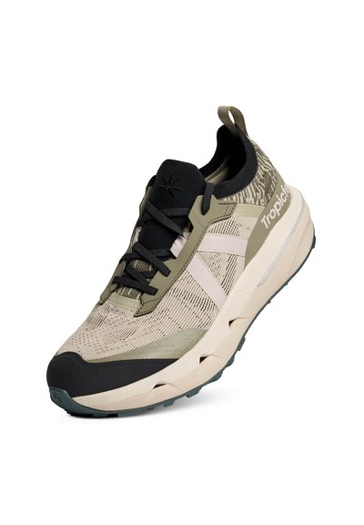 Chaussure de sport beige clair et vert olive avec lacets noirs, semelle épaisse, empeigne en mesh, et logo "Tropicfeel" sur le côté.