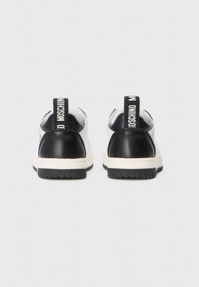 Lave sneakers med sort læderhæl og hvid krop. Har sort og hvid branding på hælkappen. Gummisål med tekstureret mønster.