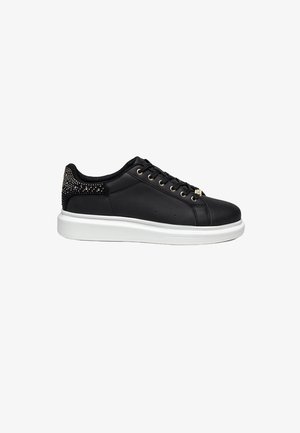 Schwarzer Sneaker mit glatter Oberfläche, goldenen Ösen, strukturierten schwarzen Akzenten an der Ferse und einer weißen Gummisohle für den Kontrast.