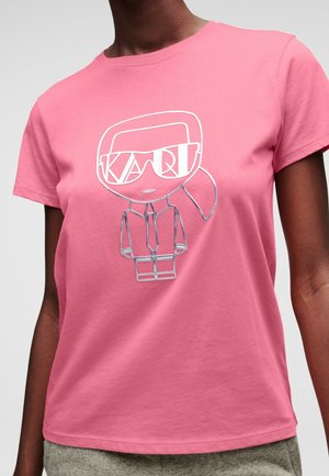 Person wearing a pink t-shirt with a silver cartoon character wearing glasses and a suit printed on the front.