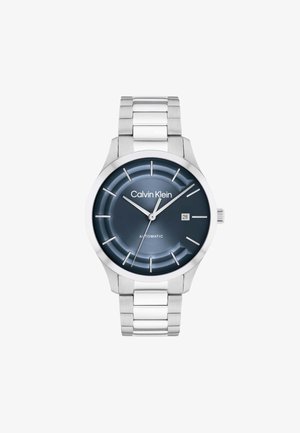Calvin Klein Herren-Silber-Metallarmbanduhr mit dunkelblauem Zifferblatt, silbernen Stundenmarkierungen, Datumsfenster bei 3 Uhr und drei Zeigern, die 10:10:39 anzeigen.