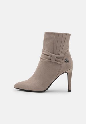 Taupefarbener Veloursleder-Stiefelette mit spitz zulaufender Zehe, hohem Stilettoabsatz, plissiertem Obermaterial, Schleifendetail und kleiner Metallblumenverzierung an der Seite.