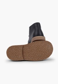 Stivale nero con tomaia in pelle liscia e suola in gomma marrone con texture. La suola presenta un motivo di battistrada dettagliato per un buon grip.