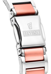 Nerūsējošā tērauda pulksteņa siksna ar pulētu apdari un rozā akcentiem. Iespējotas savienotas saites un pogas tipa sprādze. Redzams iegravēts logotips.