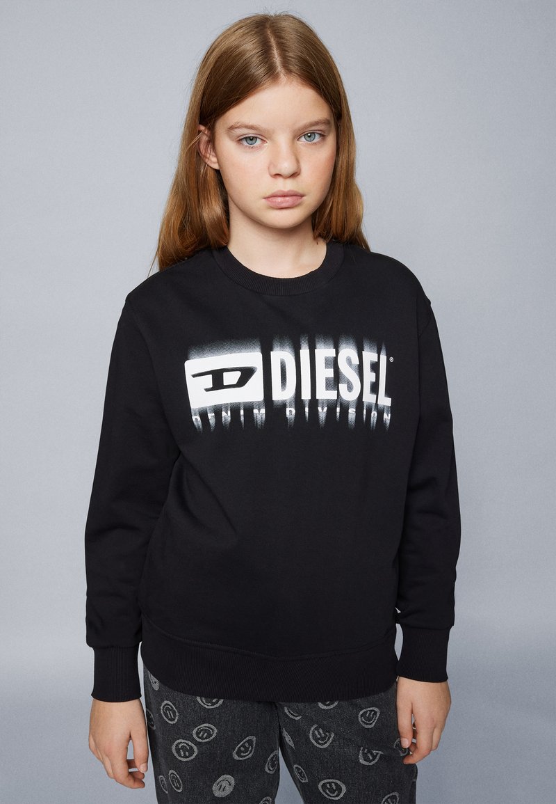 Felpa nera con un audace logo "DIESEL" bianco con effetto sfumato. Realizzata in cotone, con polsini a costine e design a girocollo.