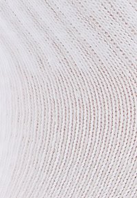 Strickstoff in zartem Rosa mit subtiler Textur und geripptem Muster. Glattes, leichtes Material; weist gleichmäßig verteilte Linien auf.