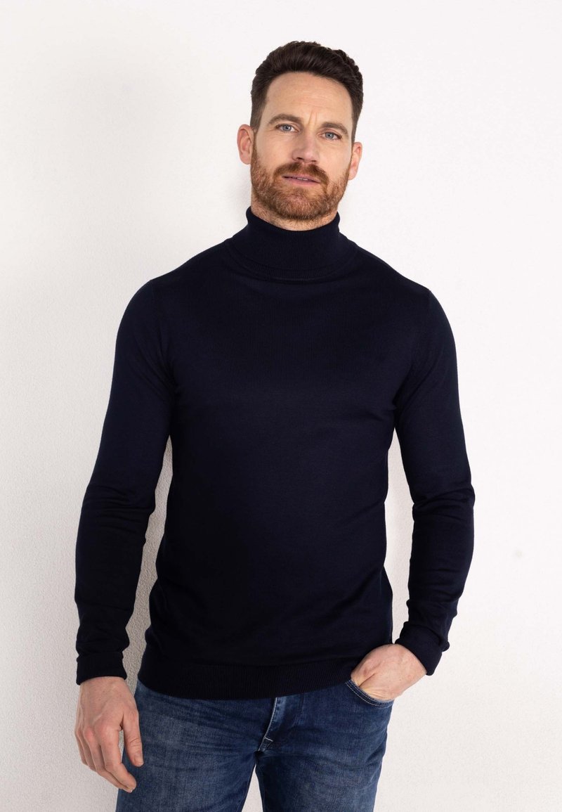 Marineblauwe coltrui gemaakt van een glad materiaal, met lange mouwen en een slim fit ontwerp met geribbelde accenten bij de manchetten en de zoom.