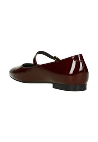 Burgunderfarbene Lacklederschuhe mit runder Zehenpartie, einem einzelnen Riemen über dem Spann und einem niedrigen schwarzen Gummihigh. Glatte Oberflächenstruktur.