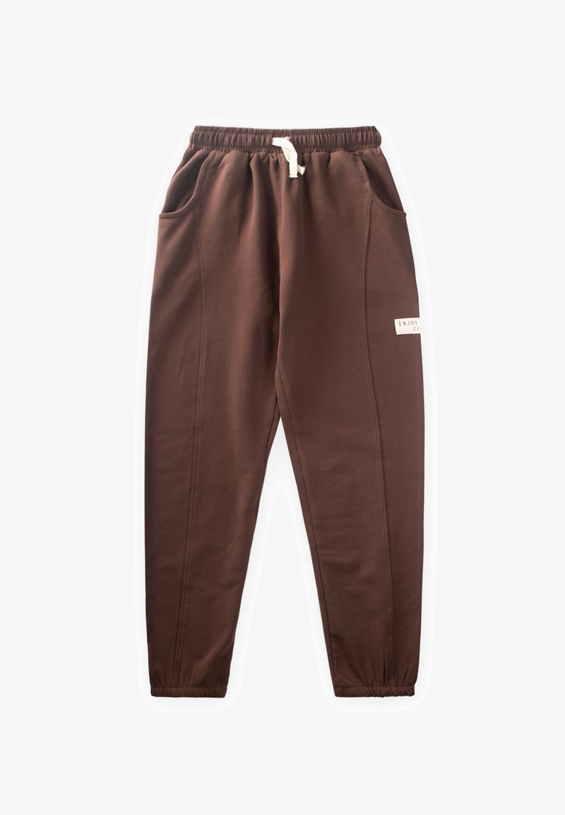 Rudos medvilnės joggeriai su elastingu juosmeniu, šnurku, šoninėmis kišenėmis ir šonine etikete. Lygi tekstūra su siaurėjančiu siluetu.