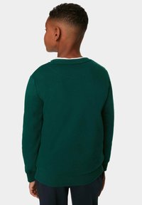 Grön sweatshirt gjord av mjukt tyg, med en rund halsringning med en kontrasterande vit innersöm och ribbade ärmslut och nederkant.
