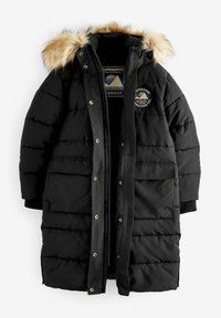 Parka longue noire matelassée avec capuche doublée en fourrure, fermeture éclair devant avec boutons-pression, écusson logo sur la poitrine et grandes poches avant.