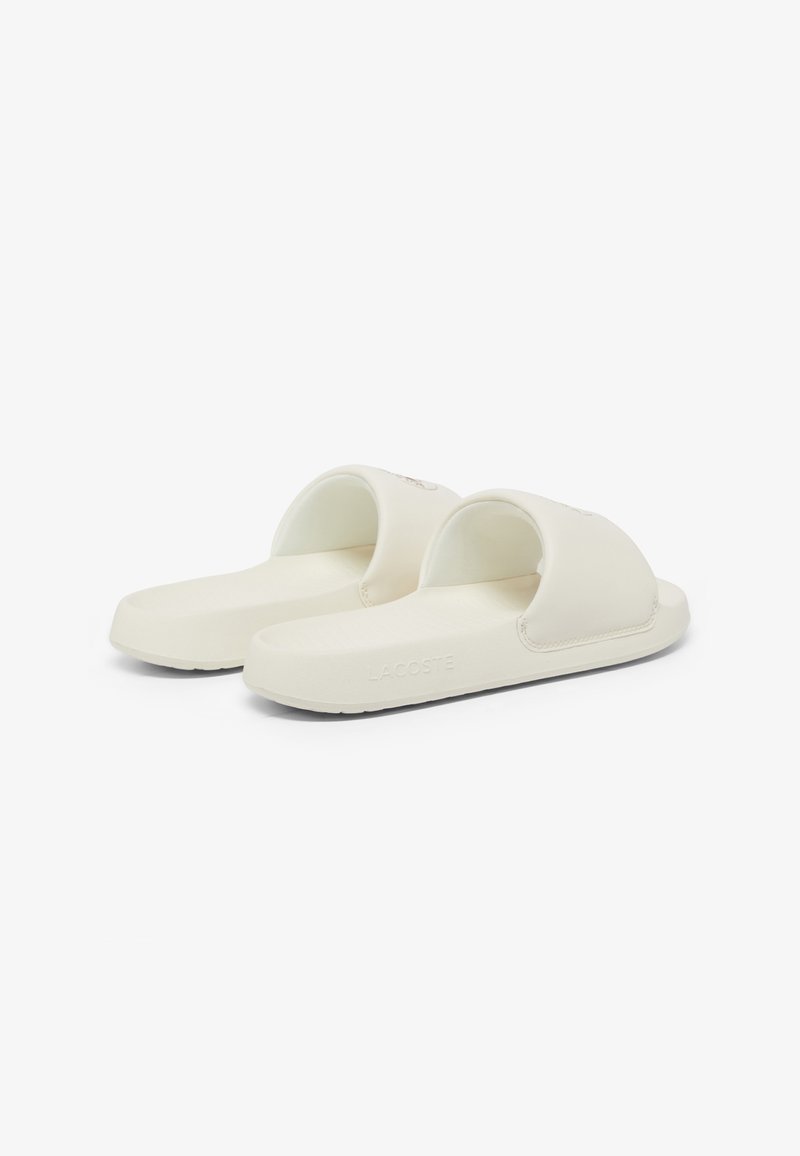 White rubber slide sandals with an open toe design, featuring a curved strap and embossed logo. Textured sole for grip.