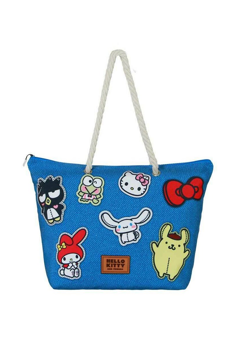 Bolsa tote azul con un acabado texturizado, que presenta varios parches de personajes coloridos y un asas de cuerda. Etiqueta de la marca en la parte inferior.