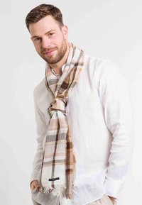 Meleg tónusú kockás sál, könnyű anyagból kész�ült, barna, bézs és krémcsíkokkal. Az élek megviselt befejezéssel rendelkeznek.