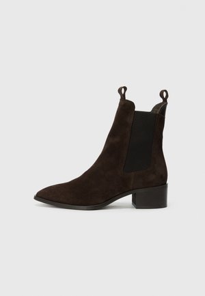 Brune suède ankelstøvler med spiss tå, elastiske sider og trekkslipper. Har en lav blokk hæl og en glatt finish.