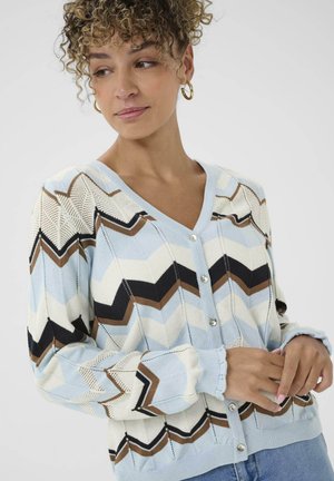 Lyseblå cardigan med et zick-zack mønster i creme, brun og sort. Har V-hals, knaplukning og ribbede manchetter. Blød strikket tekstur.