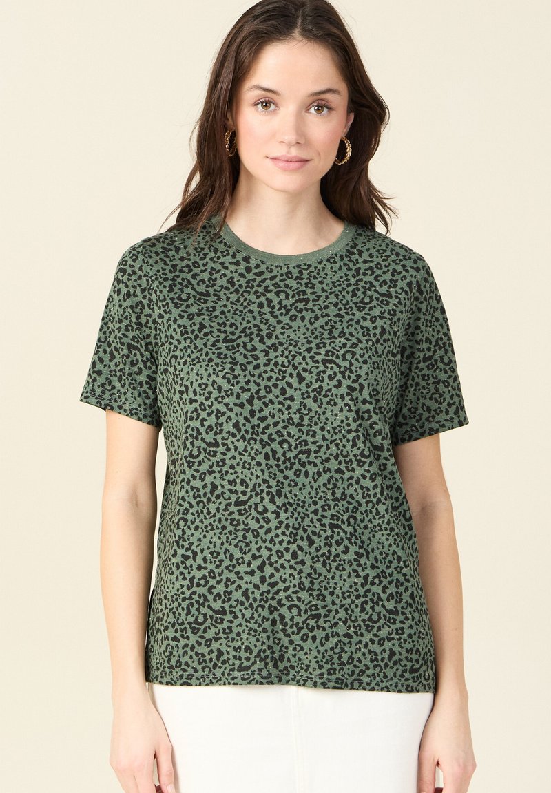 Camiseta verde con estampado de leopardo, hecha de tejido suave, con cuello redondo y mangas cortas. El patrón es negro sobre un fondo verde apagado.