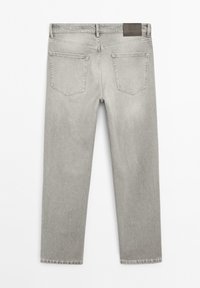 Jean en denim gris clair vu de dos avec deux poches arrière, passants de ceinture et un patch de marque en cuir foncé sur la ceinture.