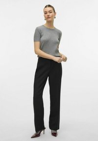 Grå ribbet bluse med korte ermer, parret med høytlivede svarte bukser og burgunder spisse hæler. Enkelt design med en tettsittende silhuett.