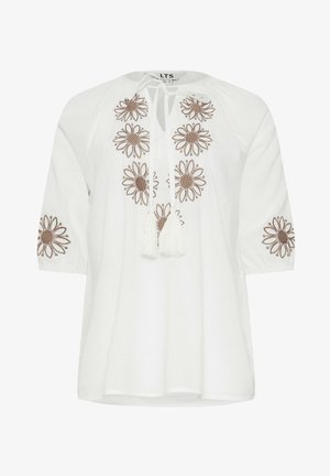 Witte blouse met ronde hals, bruine bloemenborduur op voor- en mouwen, en voorstrik met witte kwastjes.