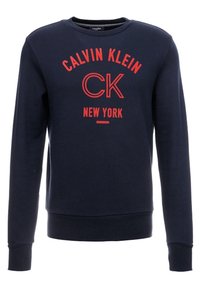 Sudadera azul marino de algodón, con cuello redondo, mangas largas y un destacado texto rojo: "CALVIN KLEIN CK NUEVA YORK" en el frontal.