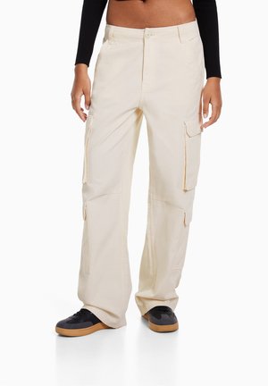 Beige cargo kalhoty s velkými bočními kapsami, rovnými nohavicemi a zapínáním na knoflík. Vyrobeny z lehké tkaniny s hladkým povrchem.