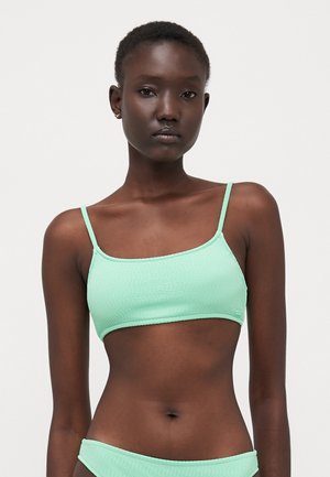 Mint green bikini top with thin adjustable straps, textured fabric, and a rectangular shape. No padding, cropped design.