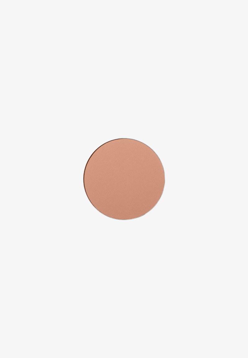 Fard à joues rond dans une nuance de marron pêche mat. Texture lisse sans paillettes, avec une surface plate et un bord net.