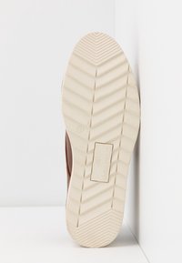 Semelle d'une chaussure beige avec motif de bande de roulement en zigzag, taille 37, et étiquette de marque rectangulaire « ANNA FIELD » embossée au centre.