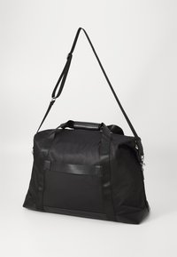 Borsa a tracolla nera realizzata in tessuto liscio e resistente. Presenta due manici superiori, una tracolla staccabile e un pannello frontale texture.