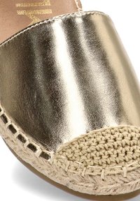 Alpargata dorada metálica tipo slip-on con puntera de yute trenzado y detalle en la suela de yute trenzado.