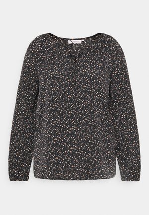 Blouse noire à manches longues avec un petit motif floral en pêche et blanc, dotée d'un col rond et d'un léger froncé aux épaules.