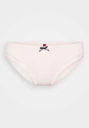 Ljust rosa trosor i mjukt tyg, med spetskant, vågiga kanter och en liten svart rosett med en logo framtill.