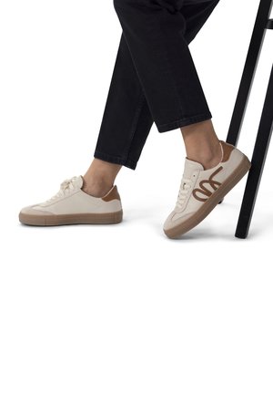 Beige sneakers with brown accents, smooth leather upper, rounded toe, flat rubber sole, and contrasting stitching detail.