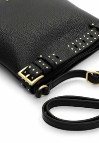 Sort læder crossbody-taske med tekstureret finish, guldfarvede beslag og nittingdetaljer langs remmen. Justerbar skulderrem medfølger.