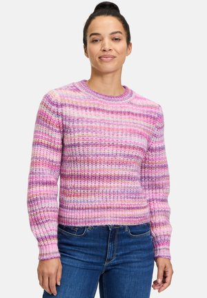 Multifarvet strikket sweater med pink og lilla striber, rund halsudskæring, ribbede manchetter og en let cropped kant. Bæres sammen med blå jeans.