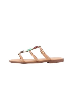 Sandalia plana color tostado con tres tiras finas, hebillas doradas y grandes piedras decorativas en colores marrón, verde y rojo.
