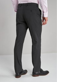 Pantalons gris charbon en tissu texturé, dotés d'une coupe droite et d'une poche arrière unique avec un bouton.