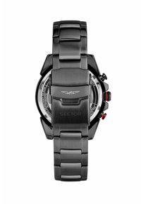 Orologio in acciaio inox nero con un design massiccio e angolare, dotato di bracciale metallico e dettagli rossi sulla corona e sui pulsanti.